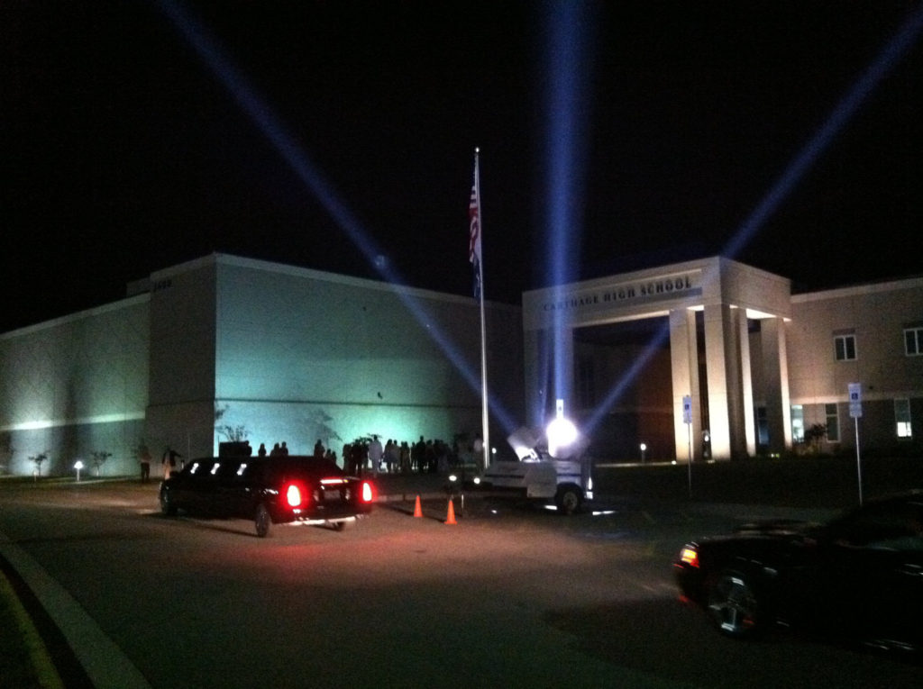 Nighttime event with lights outside a building.